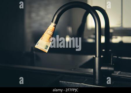 Approvvigionamento di acqua costoso. Il concetto di aumentare il prezzo dei servizi pubblici per la popolazione. Acqua calda e fredda costosa a casa. Foto Stock