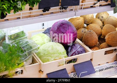 Varietà di verdure diverse cavolo viola e bianco, noci di cocco, finocchio sui ripiani nel supermercato. Vitamine e minerali. Foto Stock