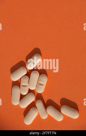 compresse di vitamina b a supporto energetico su sfondo di carta di colore arancione tema biglietto di auguri Foto Stock