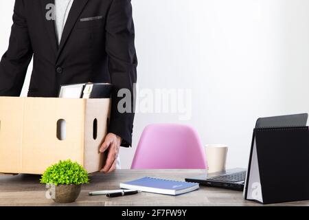 uomo che impacchette la sua appartenenza dopo le dimissioni o essere licenziato da azienda Foto Stock