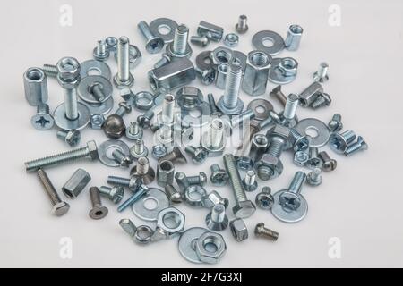 Chromeplated bulloni e dadi su sfondo bianco Foto Stock