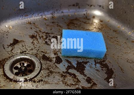 Spugna con detergente e schiuma mentre lavano il lavello in cucina. Lavare piatti e tubazioni. Spugne per il lavaggio e la pulizia di sporco. Rimozione del grasso Foto Stock