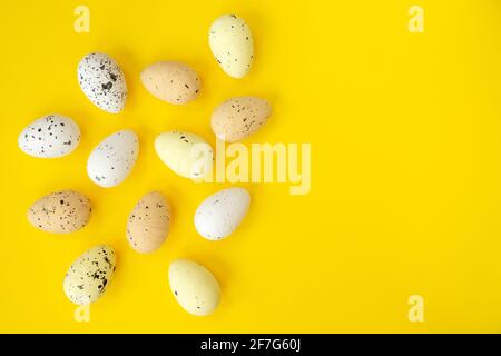Pasqua uova colorate su sfondo giallo. Vista dall'alto, concetto di Pasqua minimo. Buona carta pasquale con spazio libero e vuoto. Foto Stock