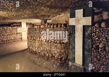Tunnel con pila di teschi e ossa e croci bianche nelle catacombe di Parigi, Francia Foto Stock