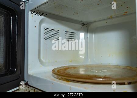 Forno a microonde sporco. Con vernice bruciata sulle pareti e tracce di grasso. Foto Stock