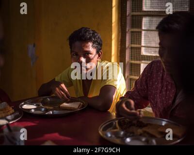 Varanasi, India. 10-16-2019. Ritratto di un adolescente maschile guardando la macchina fotografica mentre si pranza all'interno della scuola. Foto Stock