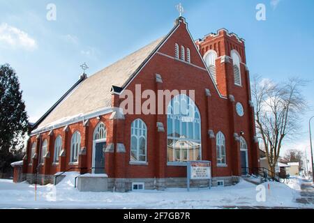 Lucan, Ontario, Canada - 6 febbraio 2021: Foto grandangolare della chiesa anglicana della Santa Trinità scattata in una mattinata di febbraio del cielo blu nel 2021. Le ciclicoli si appendono. Foto Stock