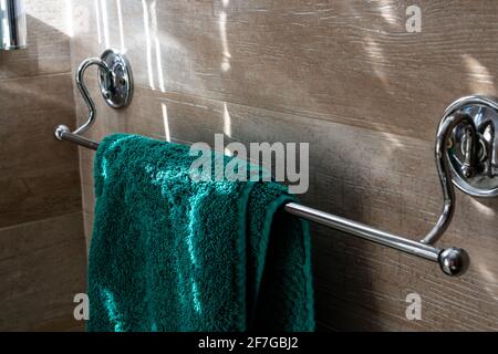Un tovagliolo turchese - verde di spugna pende su una rastrelliera d'argento in una foto interna di un bagno per gli ospiti, Londra, Ontario, Canada. Foto Stock