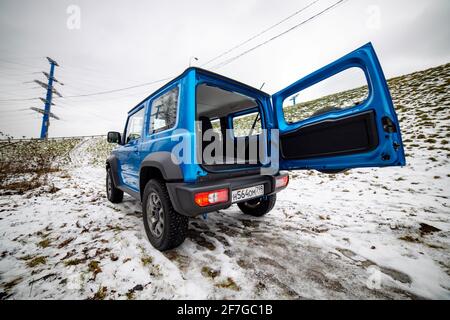 Mosca, Russia - 24 gennaio 2020: Chiusura del bagagliaio portellone aperto mini-SUV Suzuki Jimmy in neve paesaggio. Vista laterale Foto Stock