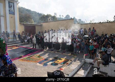 Le donne indigene guatemalteche in abiti tradizionali bruciano incenso durante la processione Semana Santa ad Antigua, un solenne rituale intriso di storia. Foto Stock