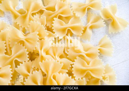 Pasta secca cruda Farfalle su fondo bianco, luce naturale Foto Stock