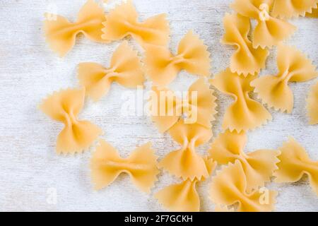 Pasta secca cruda Farfalle su fondo bianco, luce naturale Foto Stock