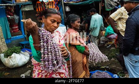 Kolkata, Bengala Occidentale, India - Gennaio 2018: Venditori di strada donne che vendono fiori e ghirlande nell'antico mercato dei fiori di Mullick Ghat nella città di Foto Stock