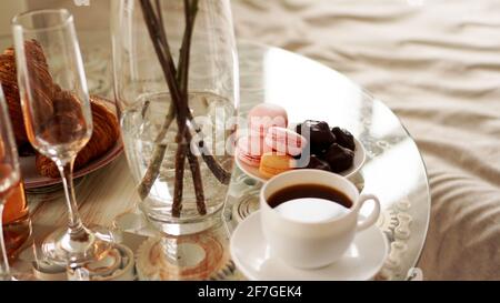 Tavolo di vetro con una tazza di caffè, macaron dolci. Foto Stock