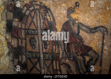 Charun, psicopompa etrusca (guida delle anime), siede con una mano appoggiata sul lungo manico del suo martello simbolico mentre custodisce l'ingresso dell'Inferno. Dettaglio della pittura murale nel 200 a.C. della tomba etrusca nella necropoli di Monterozzi dell'antica città di Tarchuna o Tarchna, oggi Tarquinia, Lazio, Italia. Foto Stock