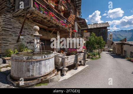 Saint-Veran, il terzo villaggio più alto d'Europa con fontana in legno in estate. Situato nel Parco naturale di Queyras, Hautes-Alpes, Alpi francesi Foto Stock