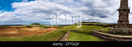 East Lothian, Scozia, Regno Unito, 7 aprile 2021. Regno Unito tempo: Sole in Lothian orientale: Dopo una mattina molto fredda di primavera, il sole è uscito e riscaldato le cose con una vista panoramica attraverso i campi di coltura patchwork della contea e la legge di Traprain dal monumento Balfour su Blaikie Heugh Foto Stock