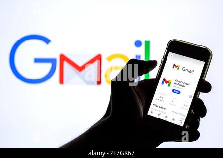 In questa illustrazione fotografica, l'app Google Gmail in App Store è visualizzata sullo schermo di uno smartphone e sullo sfondo viene visualizzato il logo Google Gmail. Foto Stock