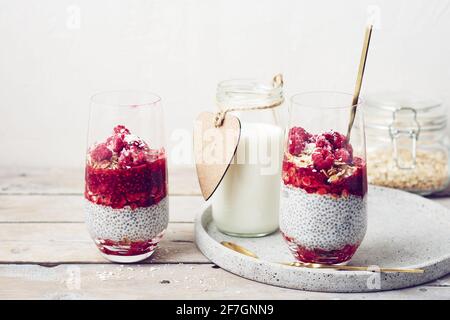 Budino di semi di Chia con granola e lamponi in un bicchiere. Foto Stock