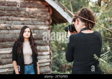 Fotografo femminile che scatta foto ritratto di una giovane ragazza. All'aperto Foto Stock