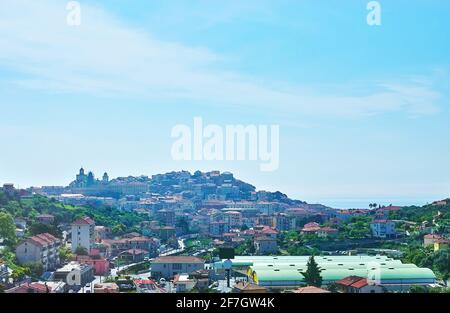 Lo skyline della vecchia Imperia con case colorate, che copre la collina, la sagoma della Cattedrale di San Maurizio e le acque blu del Mar Mediterraneo nella b Foto Stock