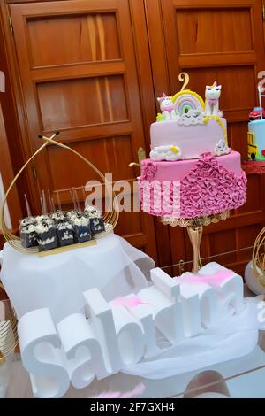 Festa di compleanno dei bambini con decorazioni colorate in tinta pastello  e unicorno arcobaleno cake.candy e frutta. Tavolo per bambini o feste di  compleanno del bambino Foto stock - Alamy