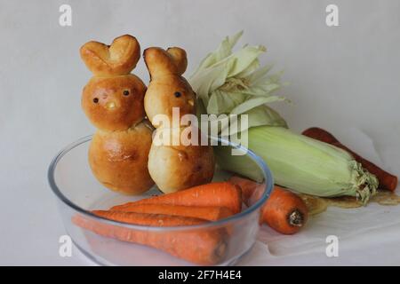 Panini di Pasqua fatti in casa. Conigli cotti a forma di coniglietto come parte della celebrazione pasquale. Scatto su sfondo bianco Foto Stock