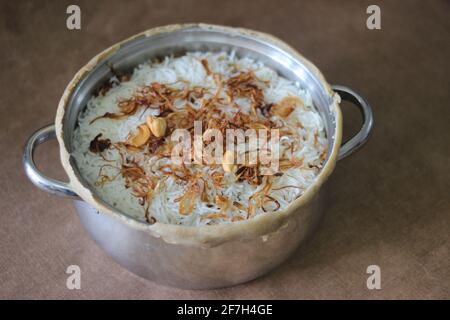 Mutton biriyani all'interno della pentola aperta dopo aver spezzato i bordi sigillati. I bordi sono stati sigillati per cuocere lentamente il riso. Un metodo per la preparazione di biriyani Foto Stock