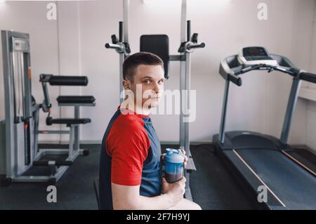 l'atleta tiene uno shaker con un frullato proteico dopo l'addestramento. nutrizione sportiva Foto Stock