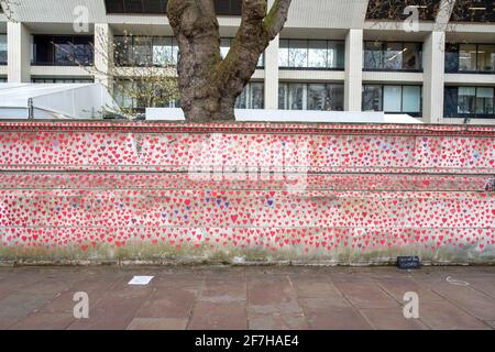 Una vista di una sezione del National Covid Memorial Wall. Il muro è adiacente al St Thomas' Hospital e viene dipinto a mano con 150000 cuori per onorare le vittime UK Covid-19, si estende su 700 metri di lunghezza. Foto Stock