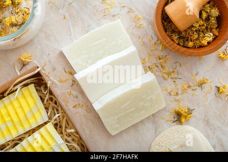 Saponette artigianali con fiori secchi alle erbe. Prodotti da bagno naturali con fiori di marigold secchi per la cura della pelle del centro benessere del corpo. Articoli da bagno per l'igiene. Foto Stock