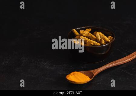 Radici e polvere tumeriche fresche è una spezie che sostiene il vostro corpo, il sistema immunitario e antiossidante Foto Stock