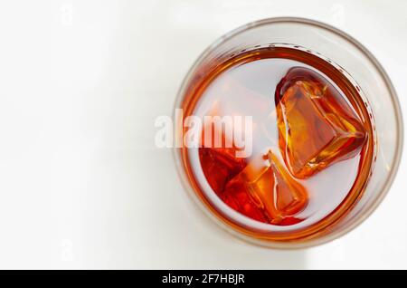 Ottimo whisky servito con cubetti di ghiaccio in un bicchiere di vecchio stile, degustazione Foto Stock