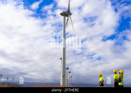 Un ingegnere e lavoratori qualificati hanno discusso il piano per la manutenzione delle turbine eoliche. Energia rinnovabile con generatore eolico con energia alternativa c Foto Stock