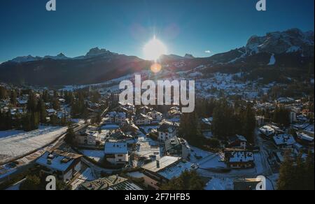 Panorama del drone aereo della città dolomita alpina di Cortina d'Ampezzo poco prima del tramonto in una giornata di sole in gennaio, guardando verso Tofana. Foto Stock