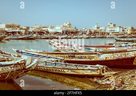 Foto d'epoca delle barche da pesca parcheggiate sulla riva di Sant Lois, una città nel nord del Senegal. Barche colorate, chiamate pirogues, sono in attesa in un canale fu Foto Stock