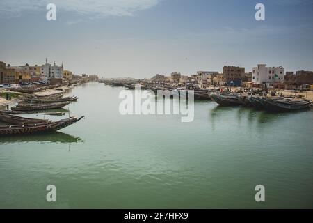 Barche da pesca parcheggiate sulla riva di Sant Lois, una città nel nord del Senegal. Barche colorate, chiamate pirogues, sono in attesa in un canale. Foto Stock