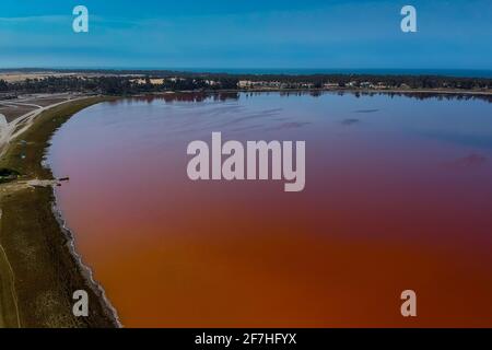 Vista aerea del Lac Rose o del lago Ralba in Senegal. Lago rosa che mostra bellezza naturale e colori ricchi in una giornata di sole. Vista sulla costa del lago e sull'atlantico Foto Stock