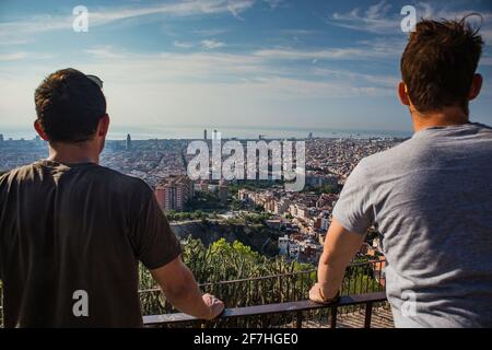 Due persone godono della vista dai bunker del Carmelo, verso Barcellona. Il paesaggio urbano di Barcellona al mattino, con le persone in primo piano. Foto Stock