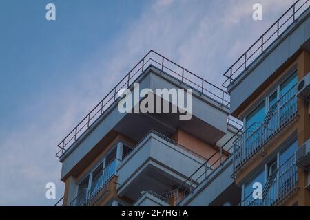 Dettaglio di un grande blocco di città residenziale a Chisinau in una serata estiva. Condominio moderno in europa orientale in giallo e bianco con moltitudine di ba Foto Stock