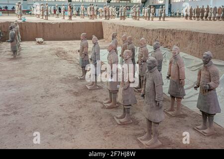 Xian, Cina - 1 maggio 2010: Esercito di terracotta di Qin Shi Huang. 2 gruppi di soldati in piedi, uno più in alto sulla sporcizia beige nella grande sala. Foto Stock