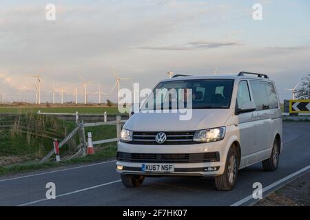 vw van su strada vicino a più turbine in Wind Farm nella costa sud, Sussex est, Inghilterra Foto Stock