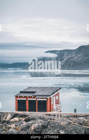 Immagine panoramica del Camp a Eqi Sermia Eqip ghiacciaio in Groenlandia. natura paesaggio con lodge cabine. Il sole di mezzanotte e rosa del cielo. Destinazione turistica Foto Stock