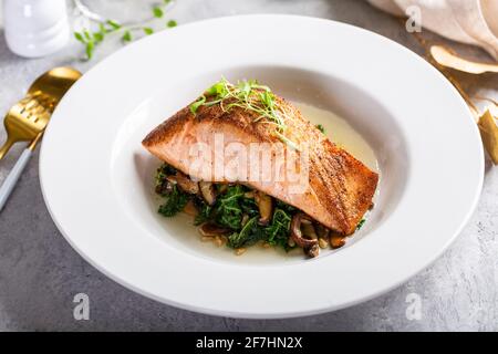 Filetto di salmone servito con verdure saltate e funghi Foto Stock
