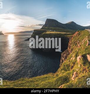 Gasadalur villaggio e Mulafossur la sua cascata iconica durante l'estate con il cielo blu. Vagar, Isole Faroe, Danimarca. Scorgo nel nord atlantico Foto Stock