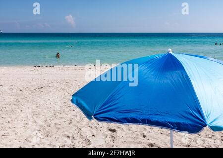 Un ombrellone blu incorniciato contro le acque azzurre dell'Atlantico al largo di South Beach, Miami Beach, Florida Foto Stock