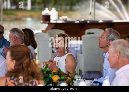 WEST PALM BEACH, FL - 14 MARZO 2021: Persone anziane felici seduti a un tavolo da eventi all'aperto, ridendo e parlando tra loro. Foto Stock