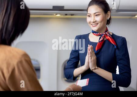 L'equipaggio di cabina o la Stewardess salutano i passeggeri in aereo, in servizio di hostess aereo o di stewardess Foto Stock