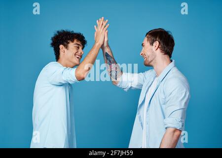 giovani ragazzi in corrispondenza t shirt e camicie divertenti saluti blu amici di sottofondo Foto stock Alamy