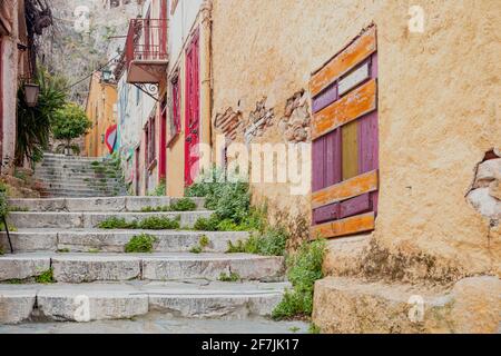 Città vecchia Plaka, Atene destinazione Grecia. Vecchi e vuoti scalini in pietra tradizionali dal basso verso l'alto, strette strade pedonali, bucato multicolore Foto Stock